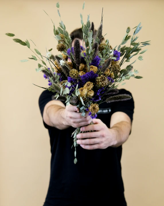 a person holding onto flowers and other plants