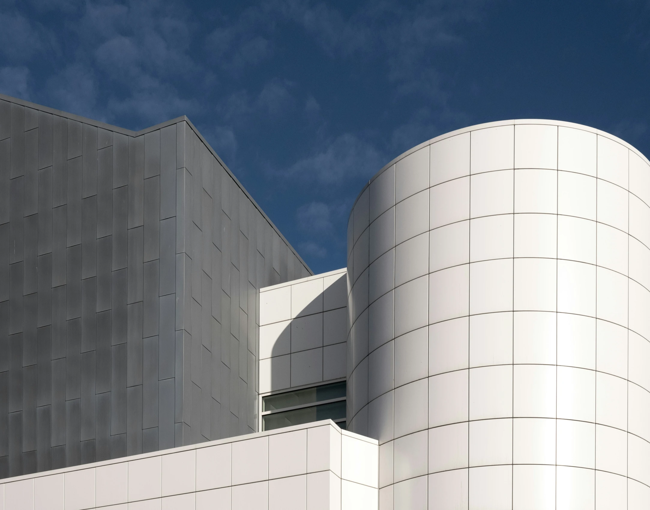 two modern buildings that have a sky background