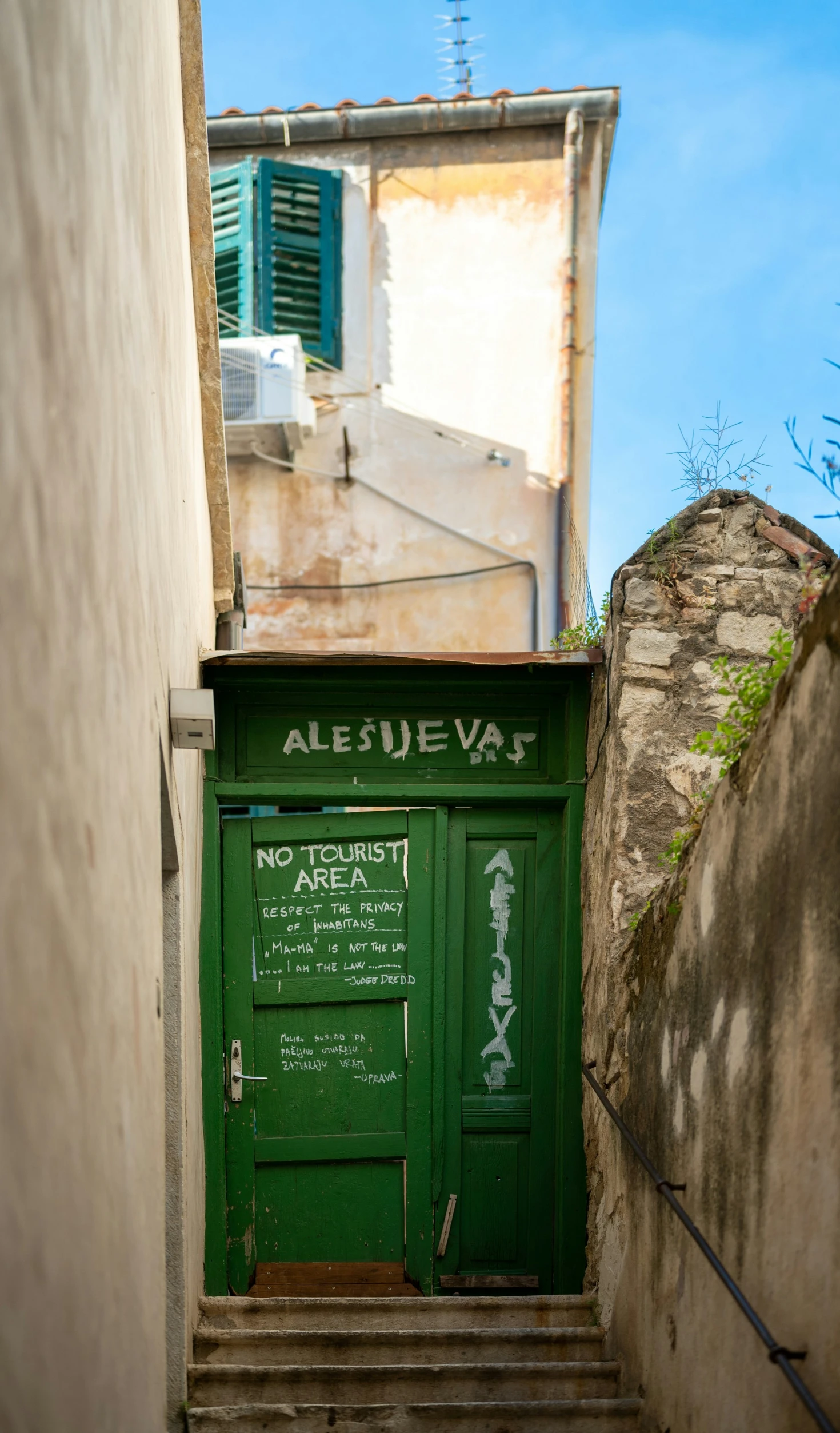 a door with green trim sitting in an alley way