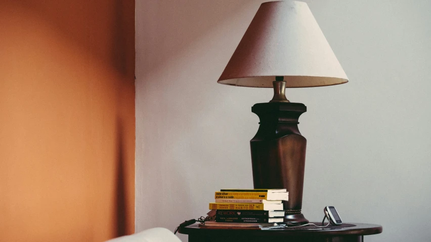 a brown table with books and a lamp on it