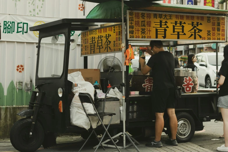 some people standing outside in front of a food cart