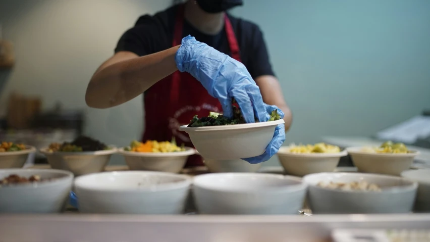 the cook is putting a blue cloth in the bowl