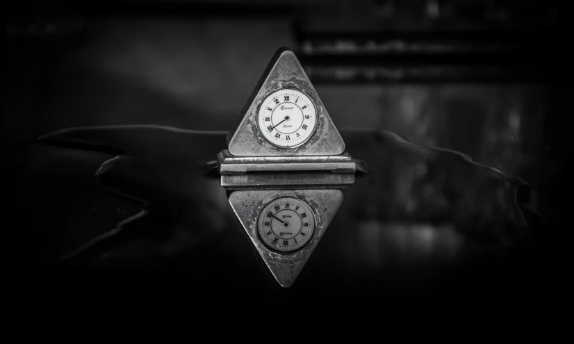 an antique clock on top of a table in the dark