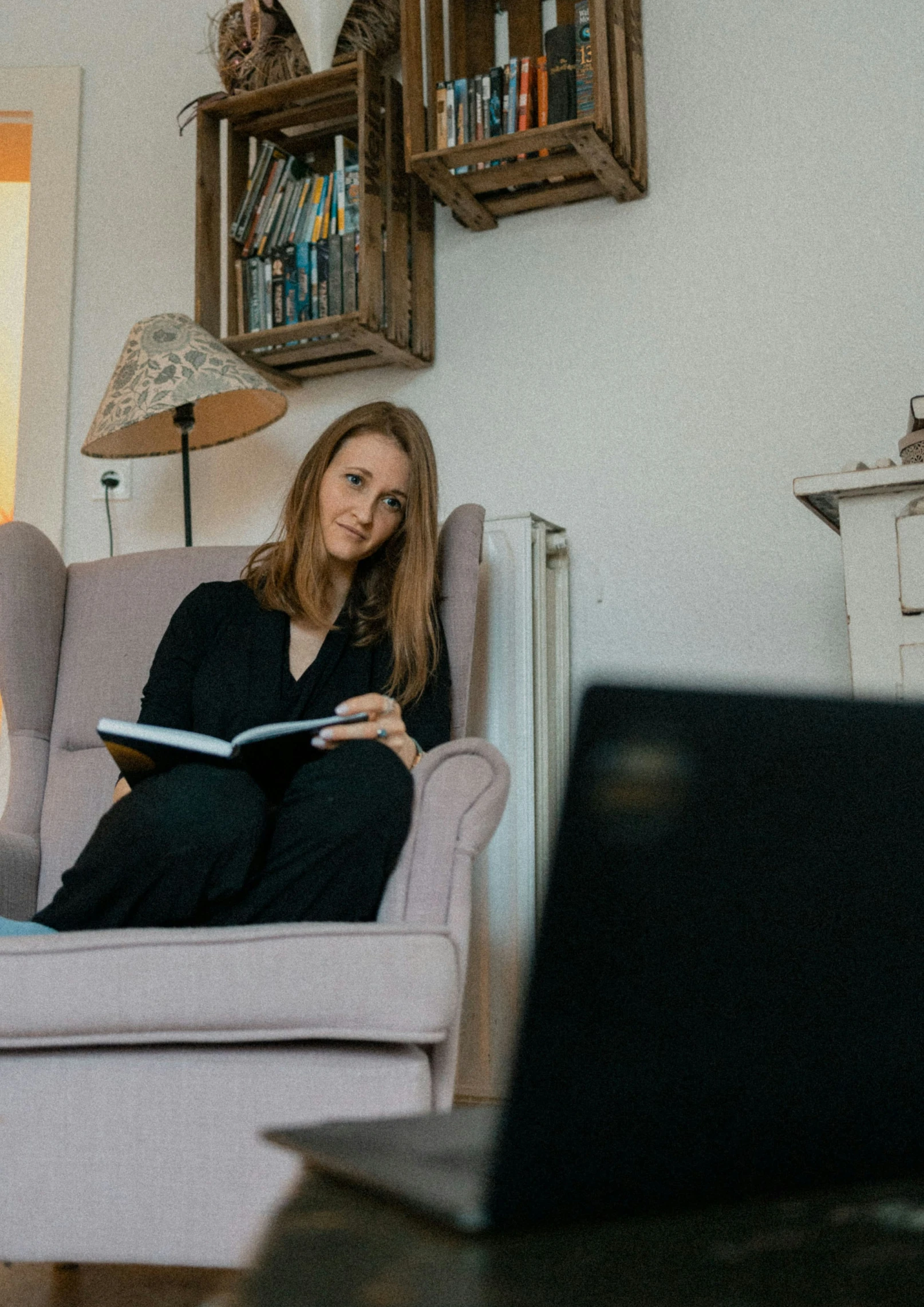 a woman sits in a chair reading a book