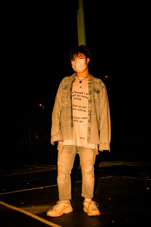 a young man with a mask standing on a sidewalk