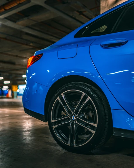 a bright blue car parked in an underground parking garage