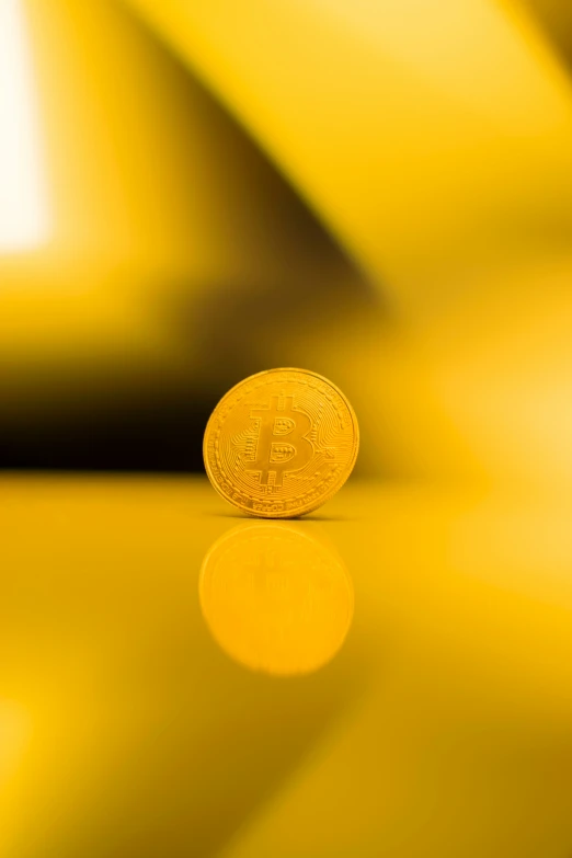 a gold bit coin that is resting on a table