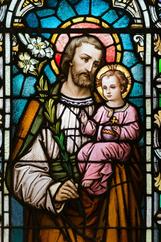 a stained glass window with a religious image of a man holding a child