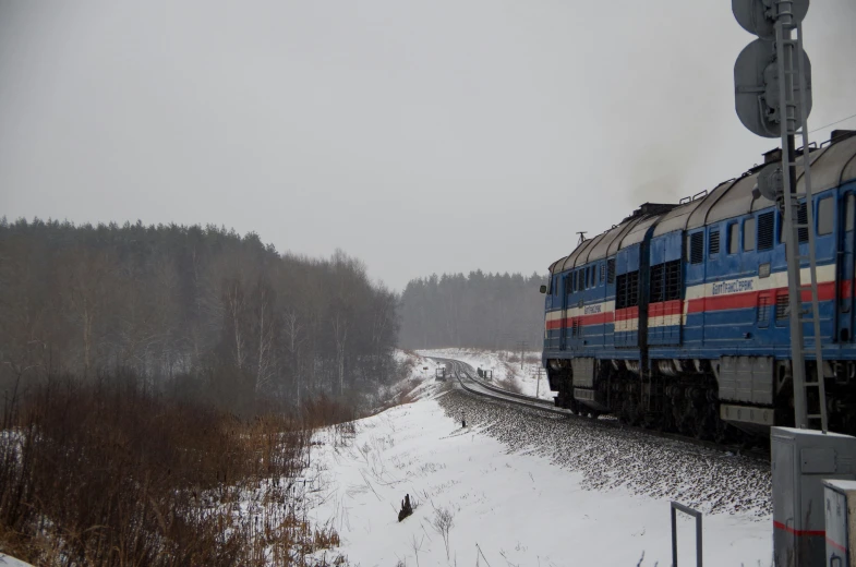 a train engine carrying carts down a snowy track