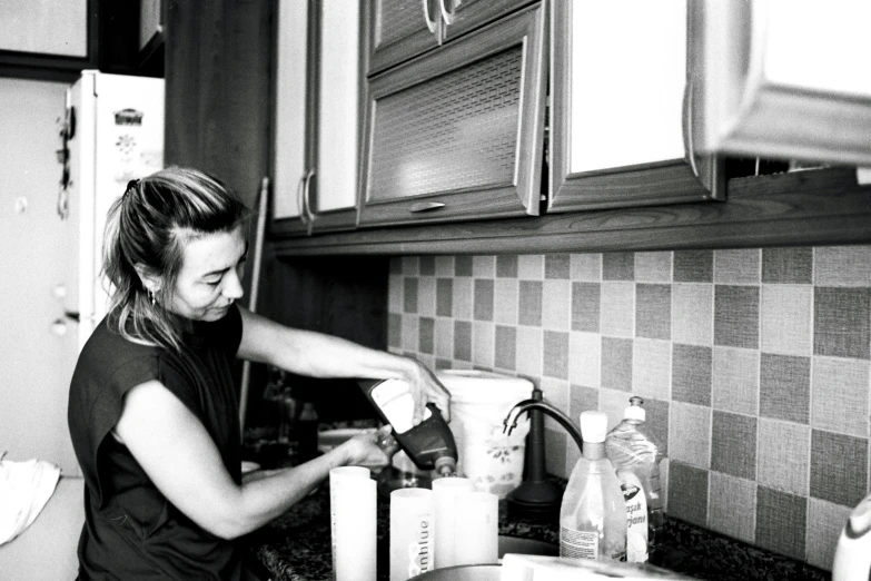 a woman using a blender on top of a kitchen counter