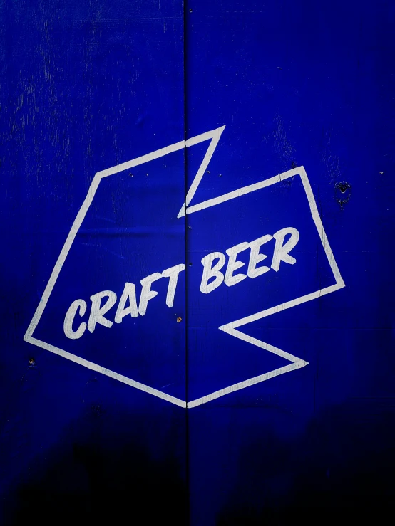 a blue sign with white lettering stating craft beer