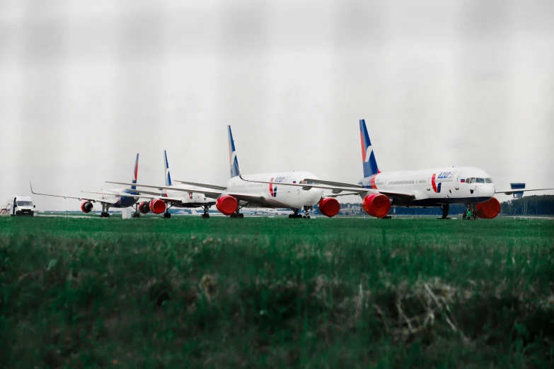 a row of red white and blue airplanes sitting on the runway