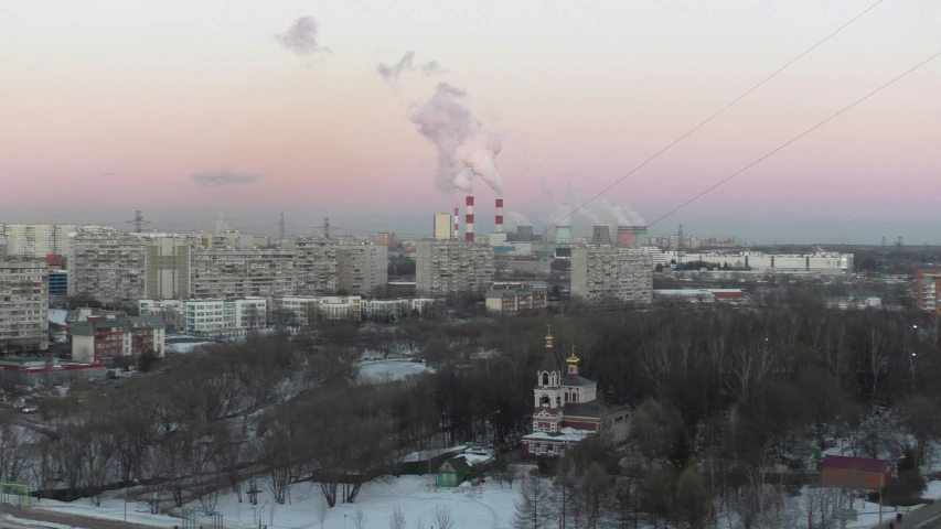 a pink sky in the background behind a city