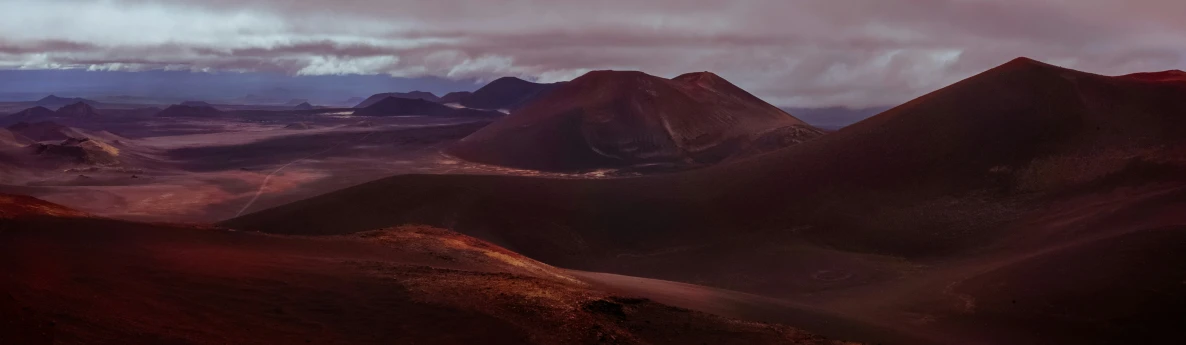 mountains and plains are shown as a cloudy sky hovers over them