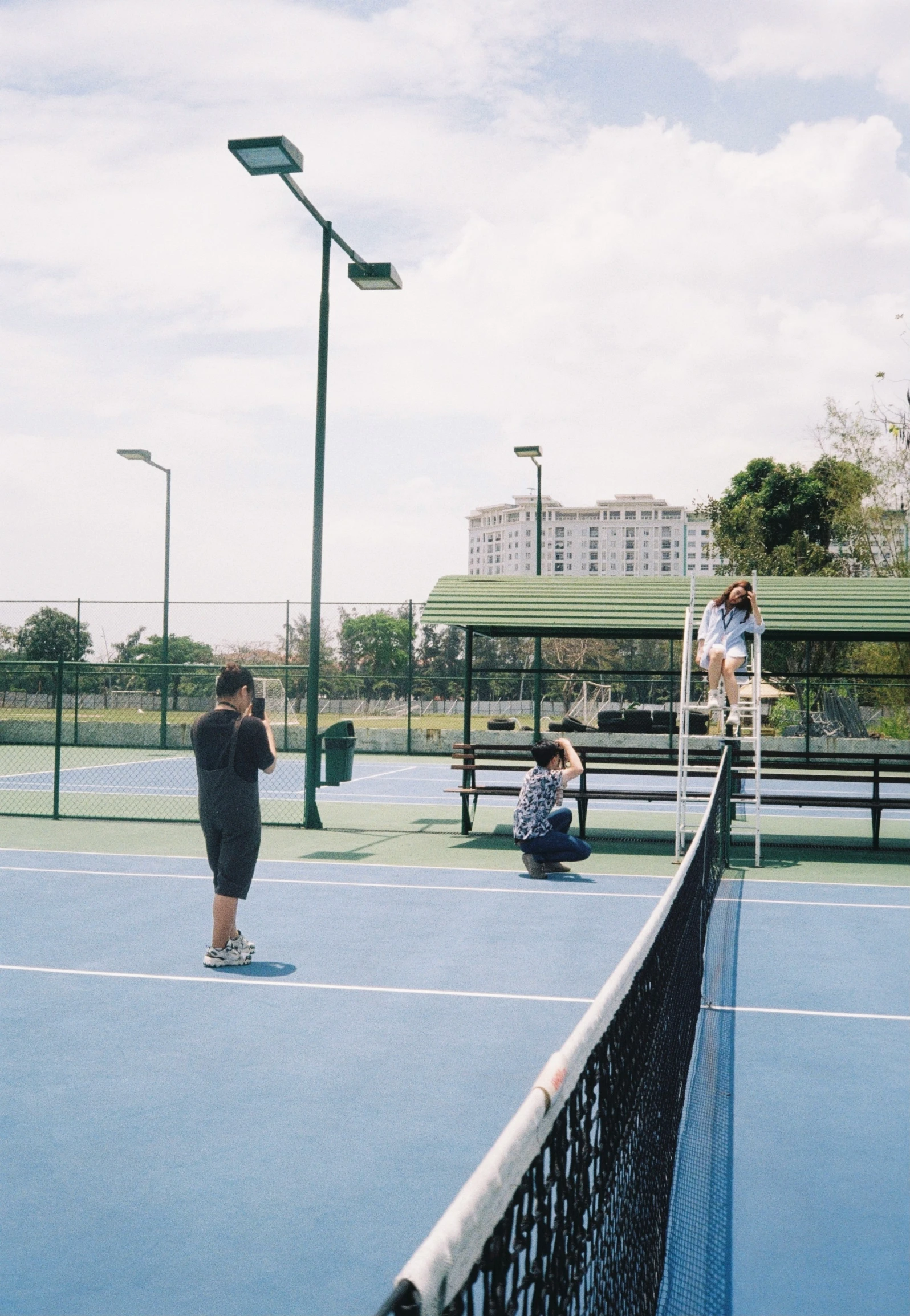 people sitting on the sidelines watching others playing tennis