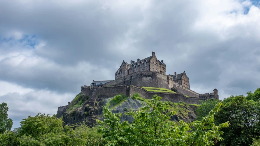 a castle on a hill above trees and bushes