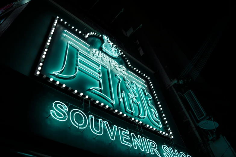 a neon sign for an outdoor theater called squeeze, with a crown