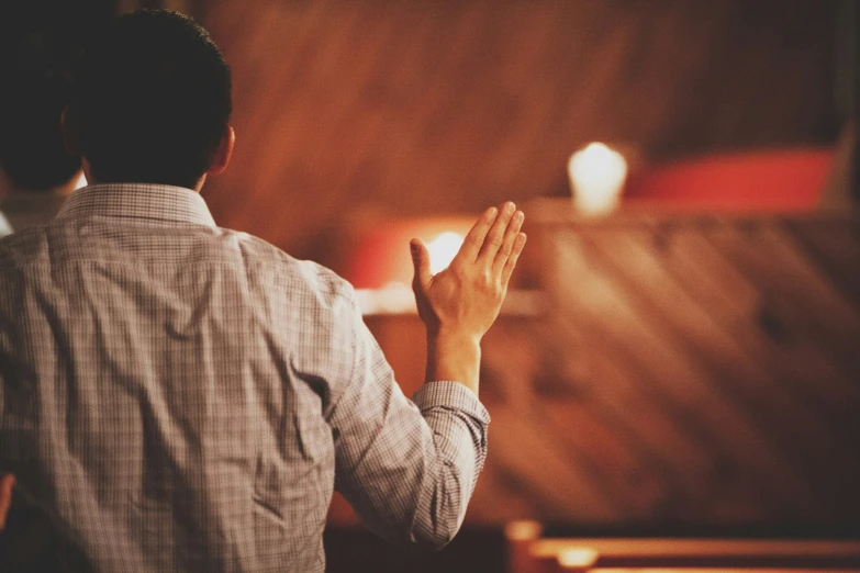 a person standing in front of a screen with their hands up