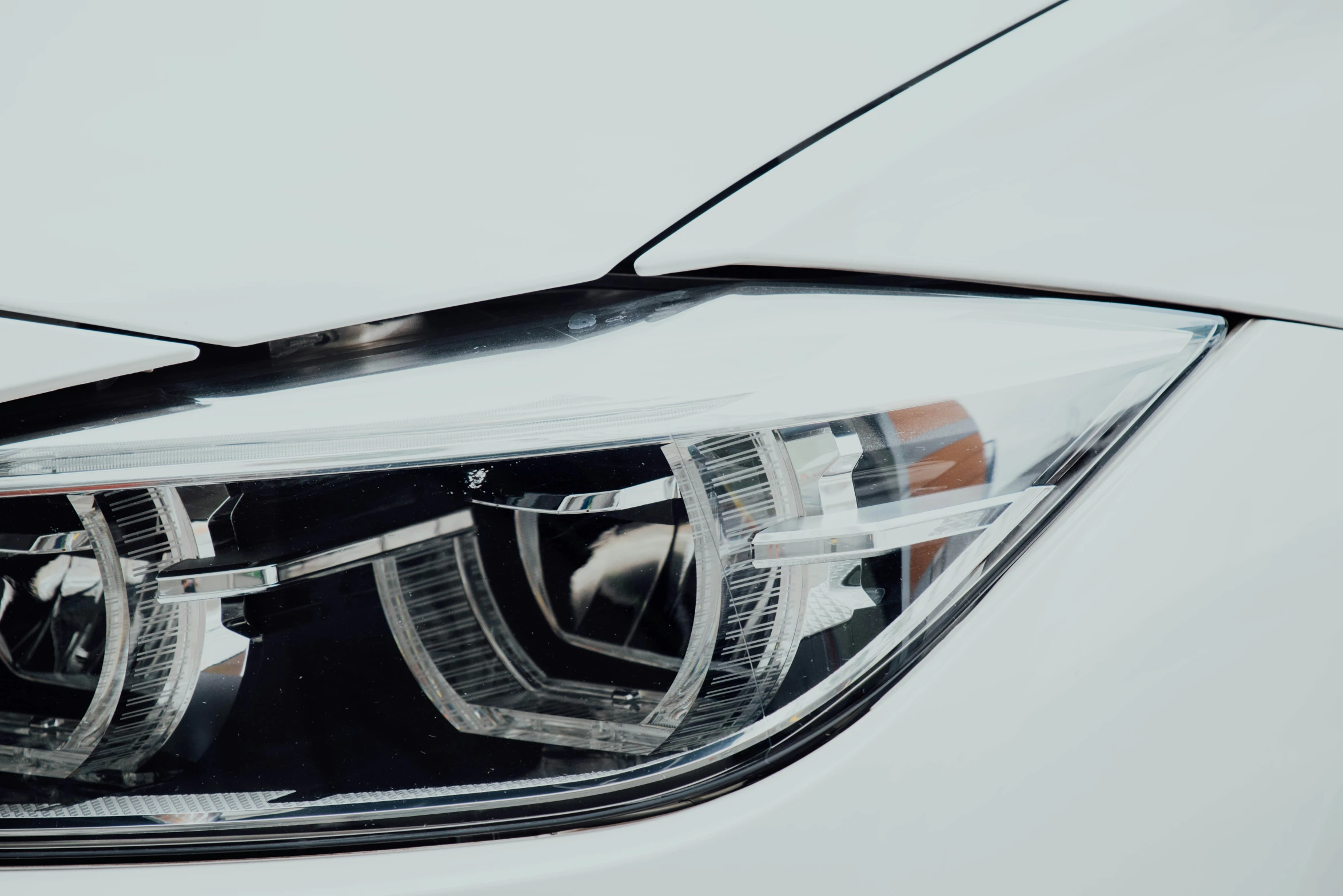 the headlights of a white car with a grey background