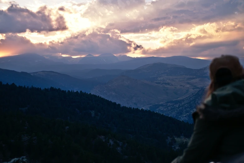 a person with their arms folded looks at the mountains