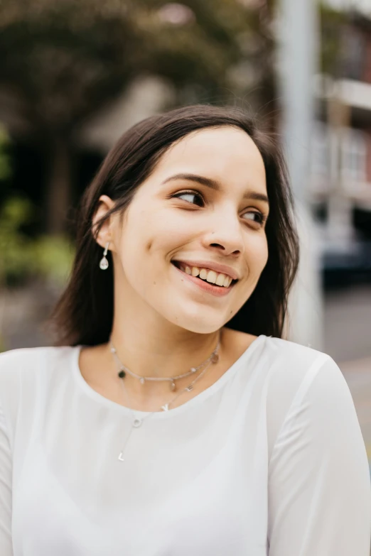 a beautiful young woman smiles brightly while posing for a po