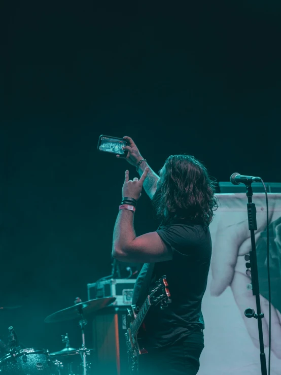 two guys standing on stage and taking pictures