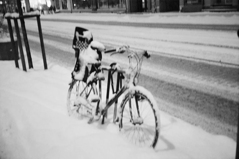 a bicycle is sitting in the snow by the street