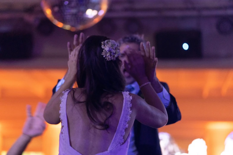 bride and groom holding hands high while dancing