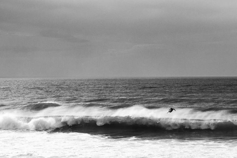 surfers riding surfboards in the ocean on a very dark day