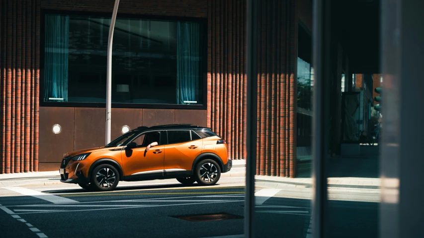 orange car parked on street next to brick building