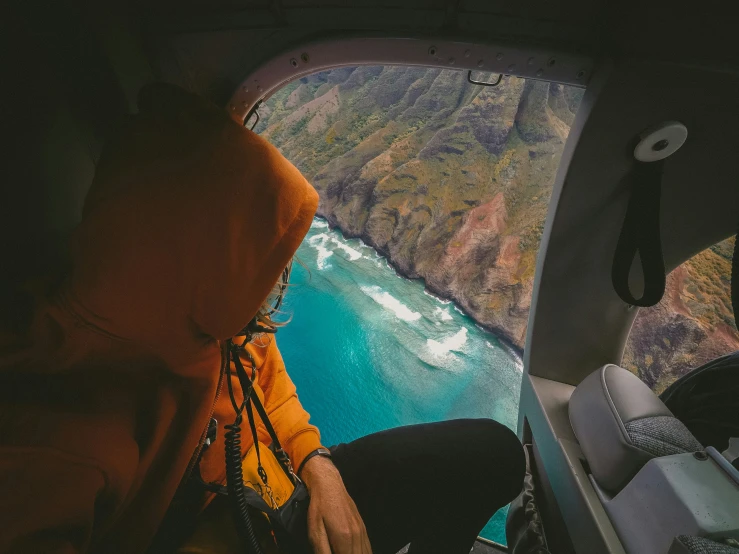 a person sitting in the cockpit of an airplane looking out over the ocean