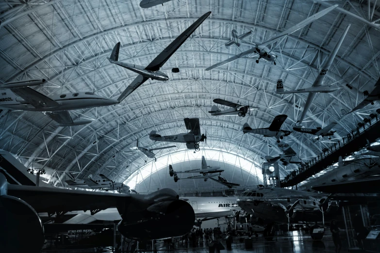 planes are flying through a dimly lit hanger