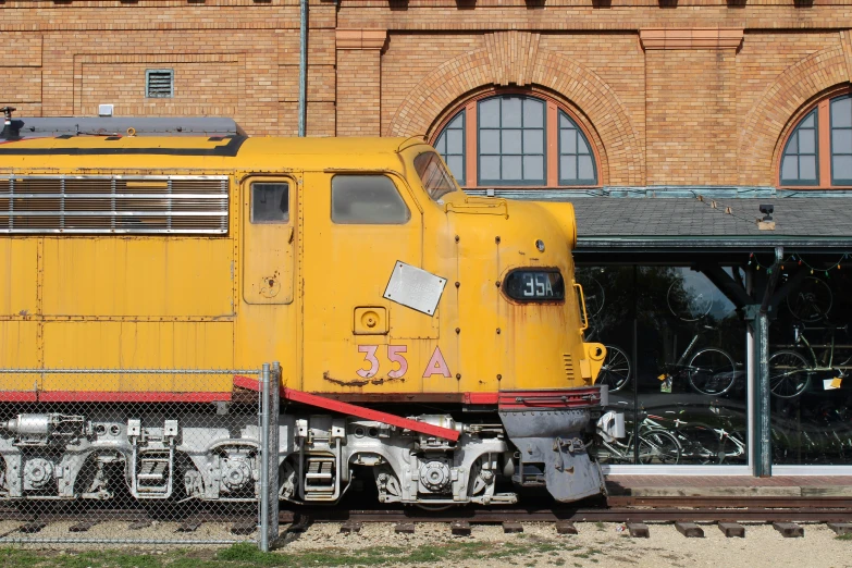 a large train is painted yellow on the tracks