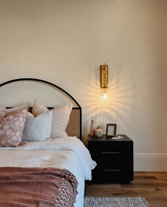 a bed sitting in a room under a wall light