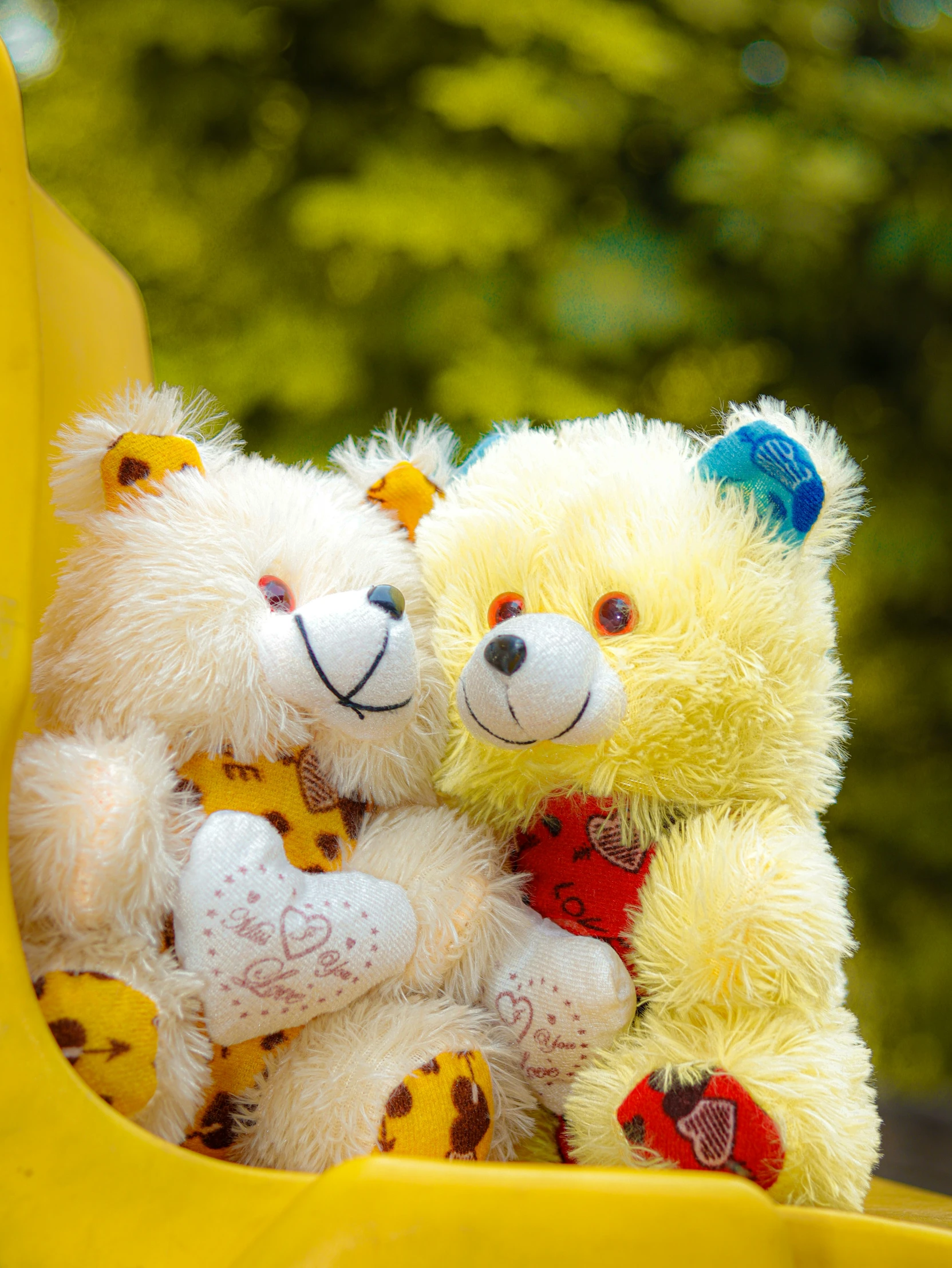 two teddy bears sitting in a toy swing