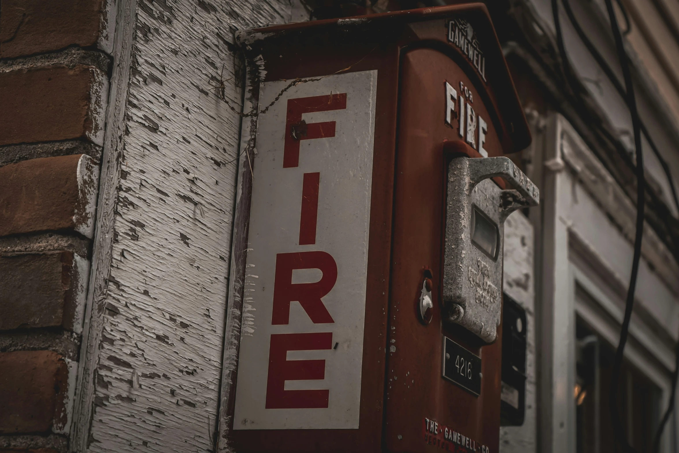 an old fire meter attached to the side of a building