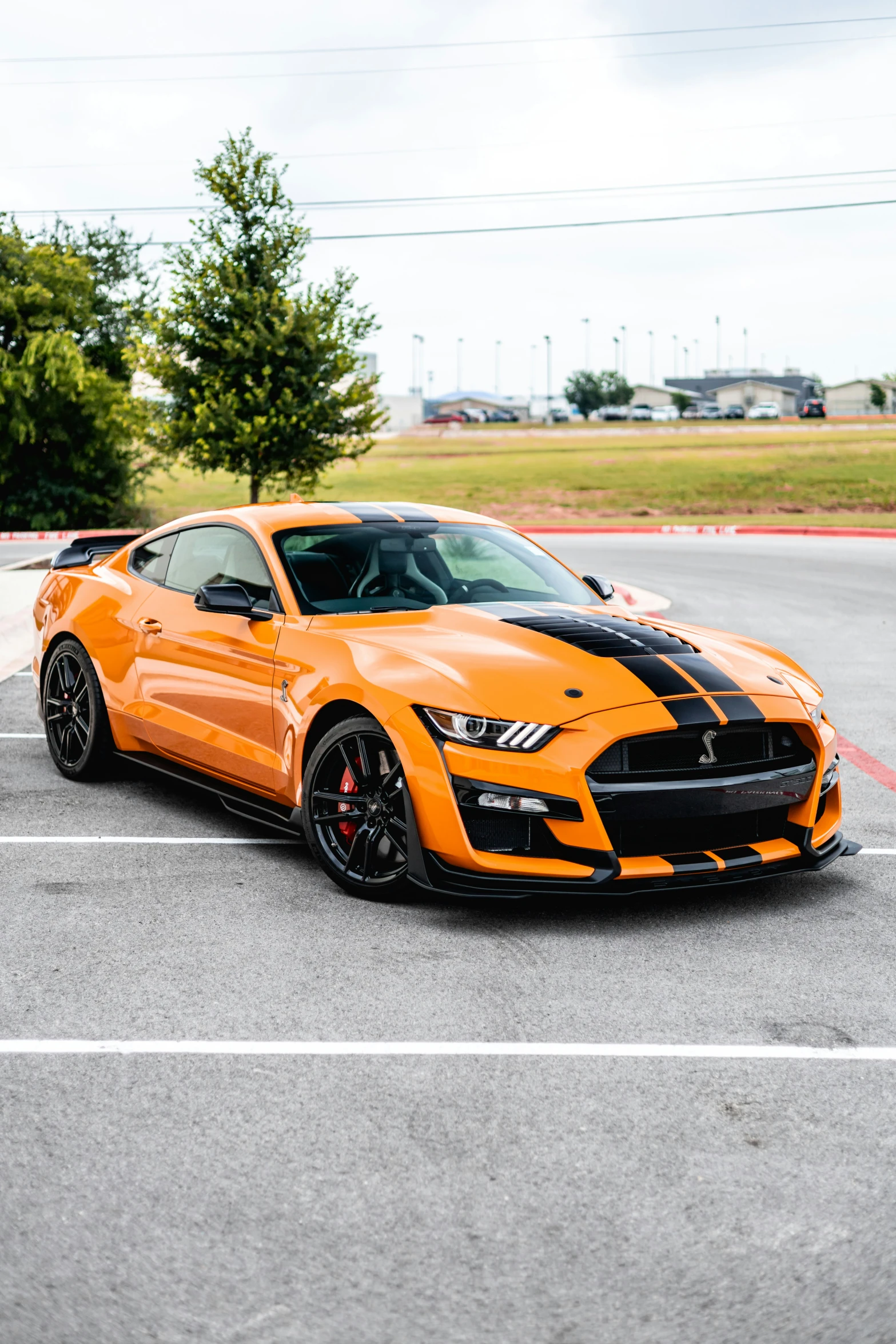 a yellow mustang is parked in the parking lot