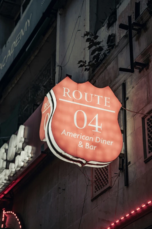 an orange sign is hanging off the side of a building