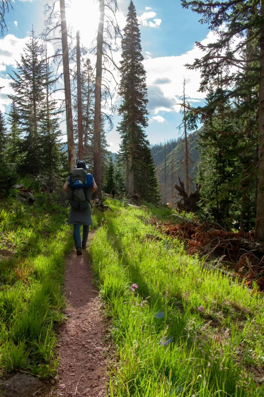 a man with backpack walking up the trail