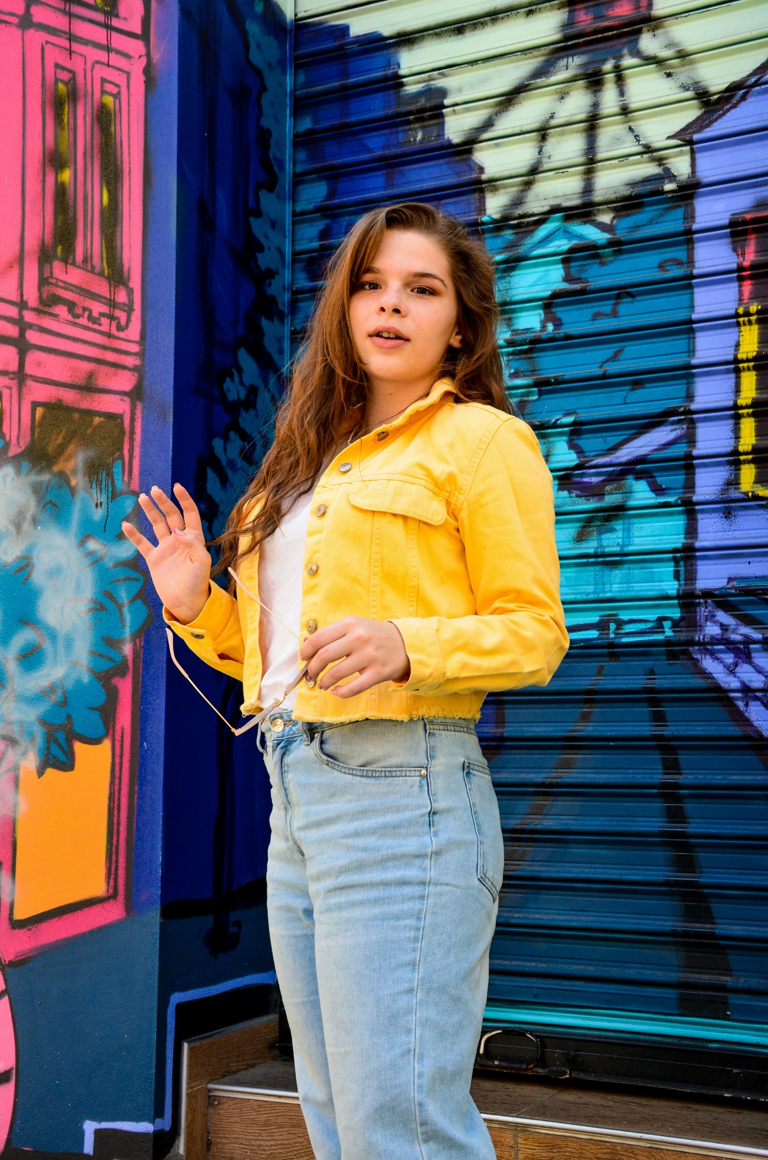 a girl standing next to a colorful wall