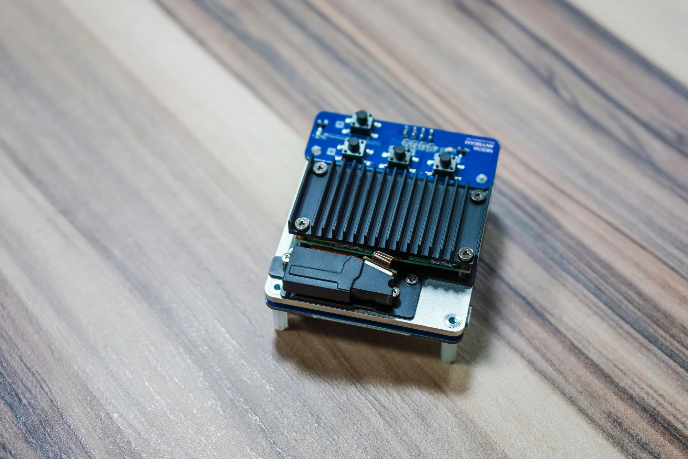 a circuit board that is connected to a small blue plastic device