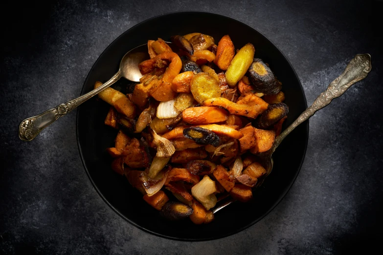 a dish with potatoes and some spoons on a table