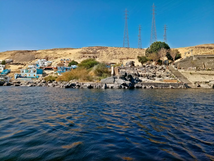 a lake next to the mountains, with power lines