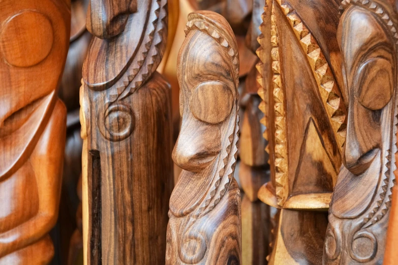 carved wood carvings sit in rows, the pattern on top