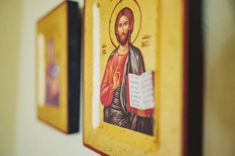 three framed images depicting the image of jesus with a binder