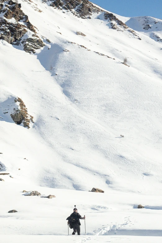 the man is walking up the snowy slope