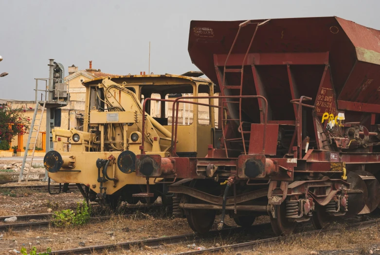 an abandoned yellow and red train car is on the track