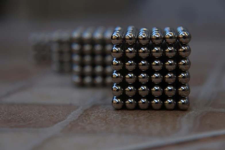 a metal ball on the ground with a large one in front