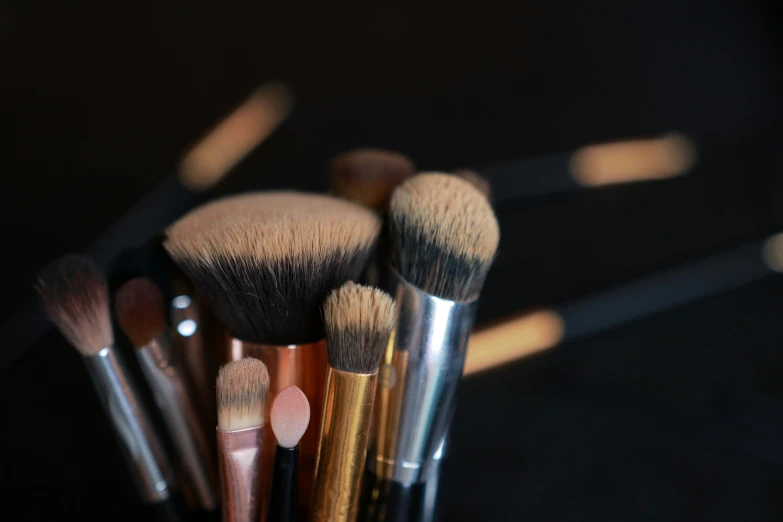 an assortment of makeup brushes is shown in a holder