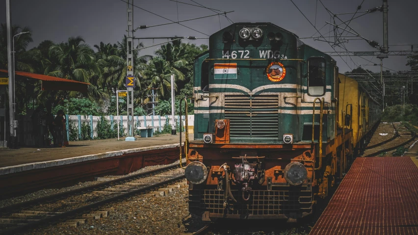 train pulling in to a train station on a stormy night